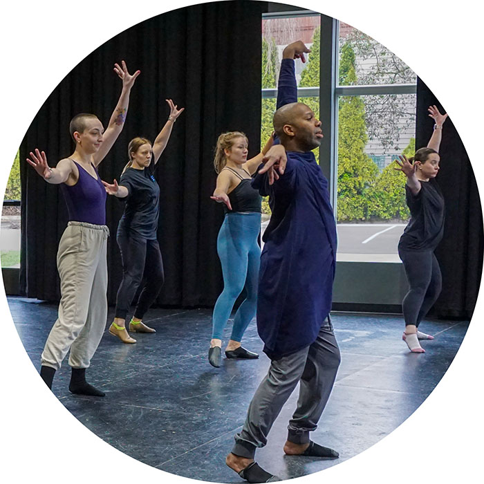 Photo from one of our adult dance classes. The students are posing with their arms in the air, mid movement.