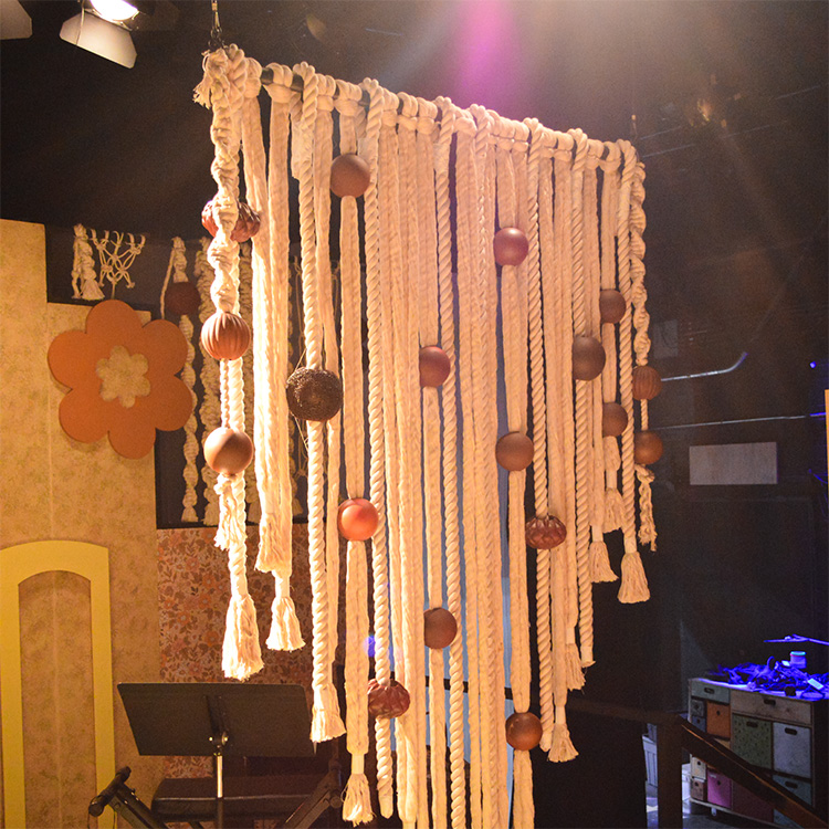 Photo of one of the macramé sections of the set for 8-Track. It is made of thick rope and huge wooden spheres, like a blown-up version of the real thing.