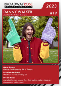 A sports card with a photo of Danny Walker. He is excitedly holding up two large foam fingers. The text on the card reads... Alma Mater: George Fox University, BA in Theatre. Favorite Musicals:Whatever one I’m working on. Dream Role: A production role on any show that tackles modern issues or deconstructs social norms.