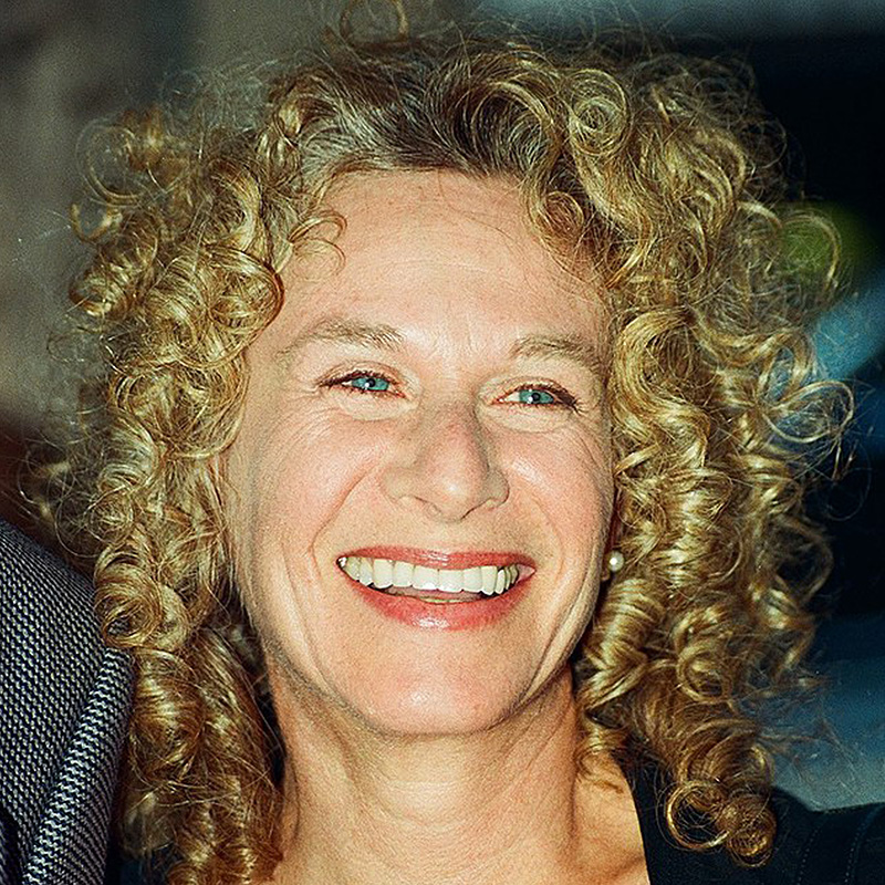 Photo of Carole King in 2002. She is smiling for the crowd of fans gathered to see her.